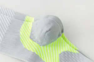 Vue détaillée de chaussettes de compression sportives grises avec bandes jaunes fluo.
