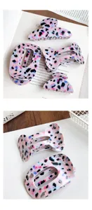 Primer plano detallado de pinzas para el pelo modernas con estampado de leopardo morado.