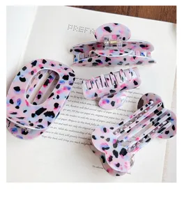 Vista detallada de primer plano de pinzas para el cabello con estampado de leopardo morado y diseños.