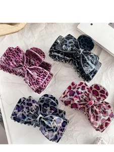 Gedetailleerd shot van leuke haarklemmen met luipaardprint en strik van acetaat.