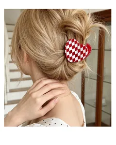 Primer plano de la pinza de pelo de corazón a cuadros rojos y blancos para peinados.