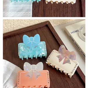 Gros plan de pinces à cheveux élégantes en acétate avec nœud et strass, design chic.