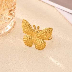 Gold stainless steel textured butterfly ring, elegant minimalist fashion jewelry detail view.