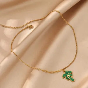 Detaillierte Nahaufnahme der goldenen Edelstahlkette mit einem leuchtend grünen Palmbaum Anhänger.