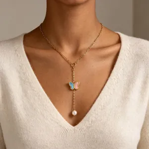Gold Y-shaped necklace featuring a pink and blue enamel butterfly and pearl pendant.