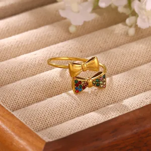 Detailed view of the double bow gold ring with colorful zircon and polished metal details.