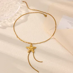 Gold Y-chain necklace detail showing textured star pendant and delicate tassel chain design.