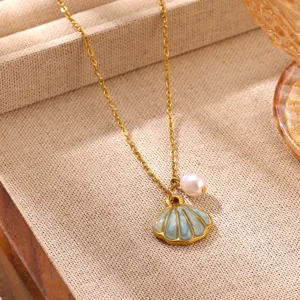 Close-up of a chic gold plated stainless steel necklace with a shell pendant and pearl.