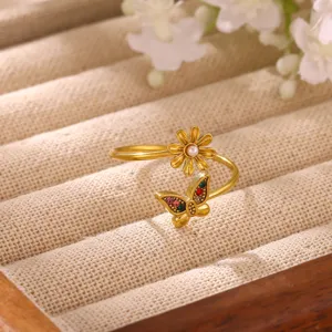 Close-up detail of the gold-plated open ring featuring a flower and butterfly with colorful zirconia.