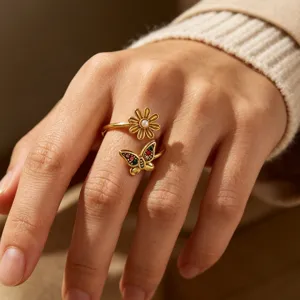 Close-up detail of the elegant gold open ring featuring a pearl flower and colorful butterfly.