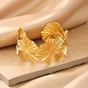 Detail shot of gold plated metal pleated leaf open cuff bracelet, minimalist geometric fashion jewelry.