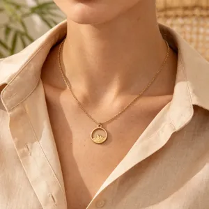 Close-up shot of a delicate gold-toned clavicle chain featuring a mountain circle pendant.