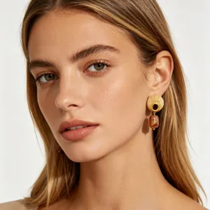 Detailed close up view of vintage shell pattern stud earrings featuring amber resin pendant.