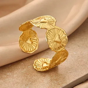 Gold tone metal floral cuff bracelet with radiant sunburst texture and heart design for daily wear.