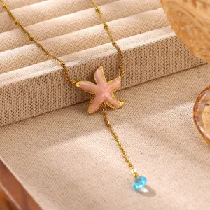 Vintage gold-plated stainless steel starfish necklace with pink enamel and blue gemstone detail.