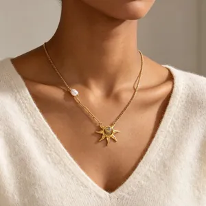 Close-up detail of gold stainless steel sun pendant necklace with elegant pearl accent.