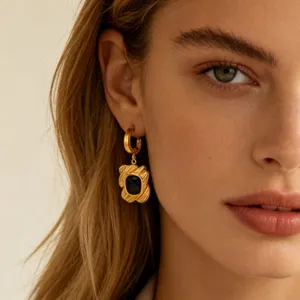 Detailed close-up shot of elegant 18k gold-plated earrings with black stone inlay, high-end design.