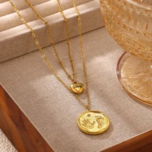 Close-up detail of double layer gold stainless steel necklace with heart and footprint pendants.