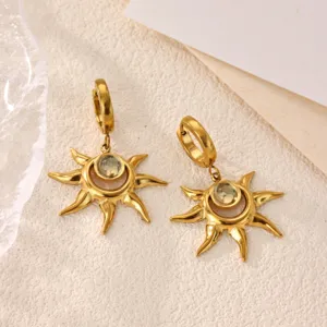 Detailed shot of 18k gold plated stainless steel sun earrings with crystal center.