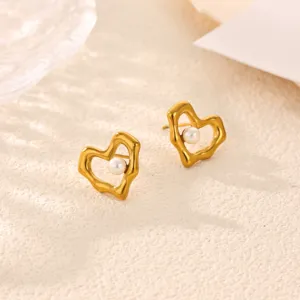 Close-up detail of chic gold irregular heart earrings featuring a delicate central white pearl.