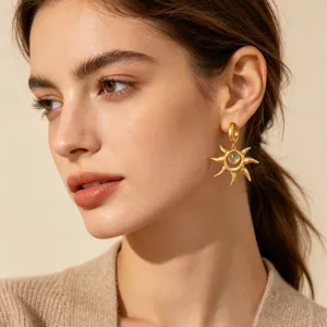 Close-up detail of 18k gold stainless steel sun earrings worn by a model, elegant design.