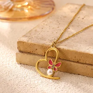 Gold stainless steel heart pendant necklace featuring pink enamel butterfly and pearl detail.