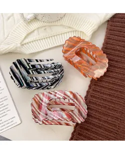Detailed shot of trendy resin flat shell hair claw clips in multicolor stripe designs.