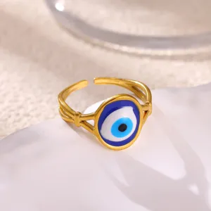 Close-up of gold stainless steel evil eye open ring, blue enamel charm fashion jewelry.
