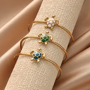 Elegant gold-plated turtle bracelets featuring white, green, and blue shell charms. Perfect chic accessory.