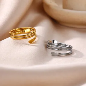 Close-up detail of stylish multi-layer open wrap stainless steel rings in gold and silver colors.