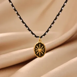 Detailed shot of a stylish gold sun heart pendant necklace with black braided rope chain.