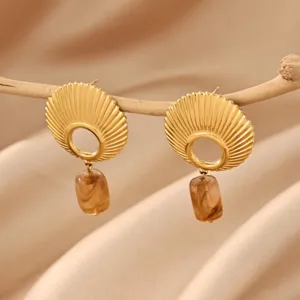 Gold stainless steel shell texture earrings with amber resin pendant, detailed shot.