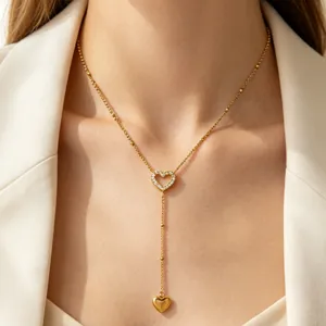 Gold lariat necklace for women featuring a paved heart pendant and drop charm. Elegant design.