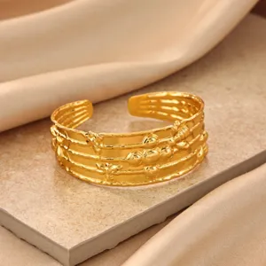 Gold multi-strand cuff bracelet featuring delicate bee and bead textured design details.