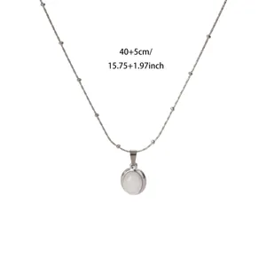 Detailed close-up of stainless steel oval white stone pendant necklace with bead chain.