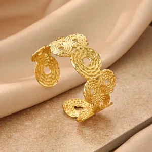 Gold geometric cuff bracelet with textured pleated design, elegant open metal bangle.