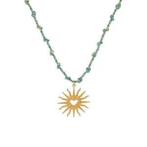 Elegant gold sun pendant necklace featuring a heart cutout and blue braided cord for women.