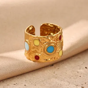 Detailed view of the wide gold-plated stainless steel ring with colorful enamel dots.