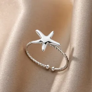 Close-up detail of a silver-toned starfish open ring with a twisted band texture.