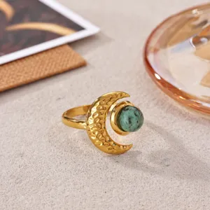 Stainless steel 18k gold moon ring with green stone, elegant fashion jewelry detail close-up.