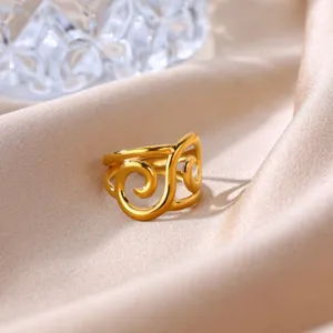 Closeup detail of 18k gold plated stainless steel open ring with stylish geometric swirl design.