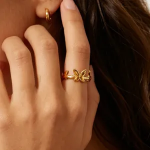 Close-up detail of the elegant gold-plated butterfly stainless steel ring worn on finger.