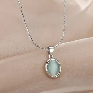 Exquisite oval mint green cat eye pendant necklace detail close-up, elegant subtle shine.