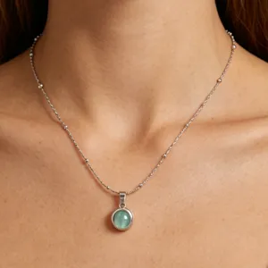 Close-up detail of the elegant titanium steel necklace featuring a green cat eye stone pendant.