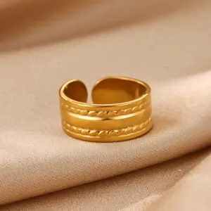 Close-up detail of the wide gold stainless steel open ring with braided texture design.