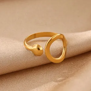 Close-up detail of a minimalist open ring with hollow geometric shape in gold finish.