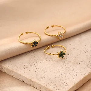Close-up detail showing three gold-plated stainless steel rings with colorful zircon flowers.