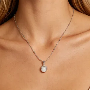 Minimalist stainless steel clavicle chain with a white crystal pendant, elegant detail shot.