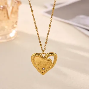 Gold heart pendant necklace featuring newborn hand and footprint with crystal detail.