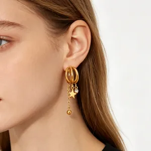 Detail view of multi-layer gold hoop earrings with hanging star and crystal charms.